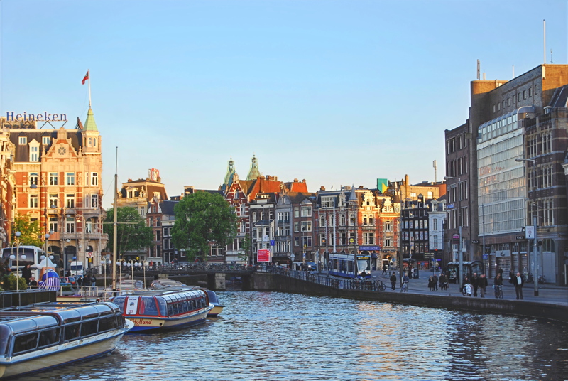 1 - A bustling canal scene with traditional Dutch-style brick buildings and historic waterways in Amsterdam